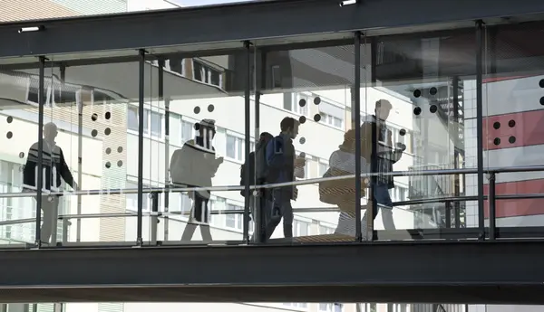 Personen, die durch einen gläsernen Gang gehen